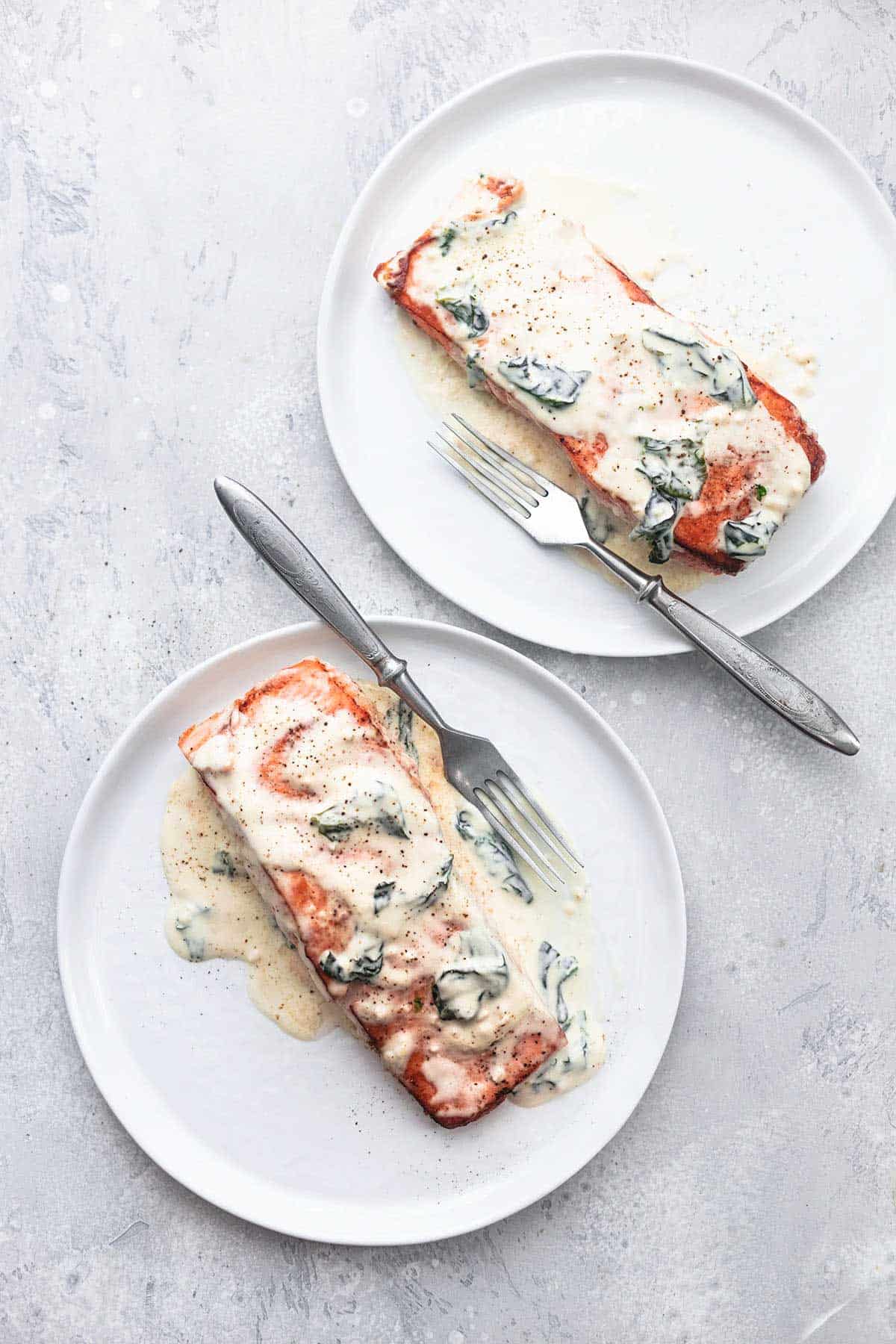 Lachs Florentiner mit einer Gabel auf zwei Tellern