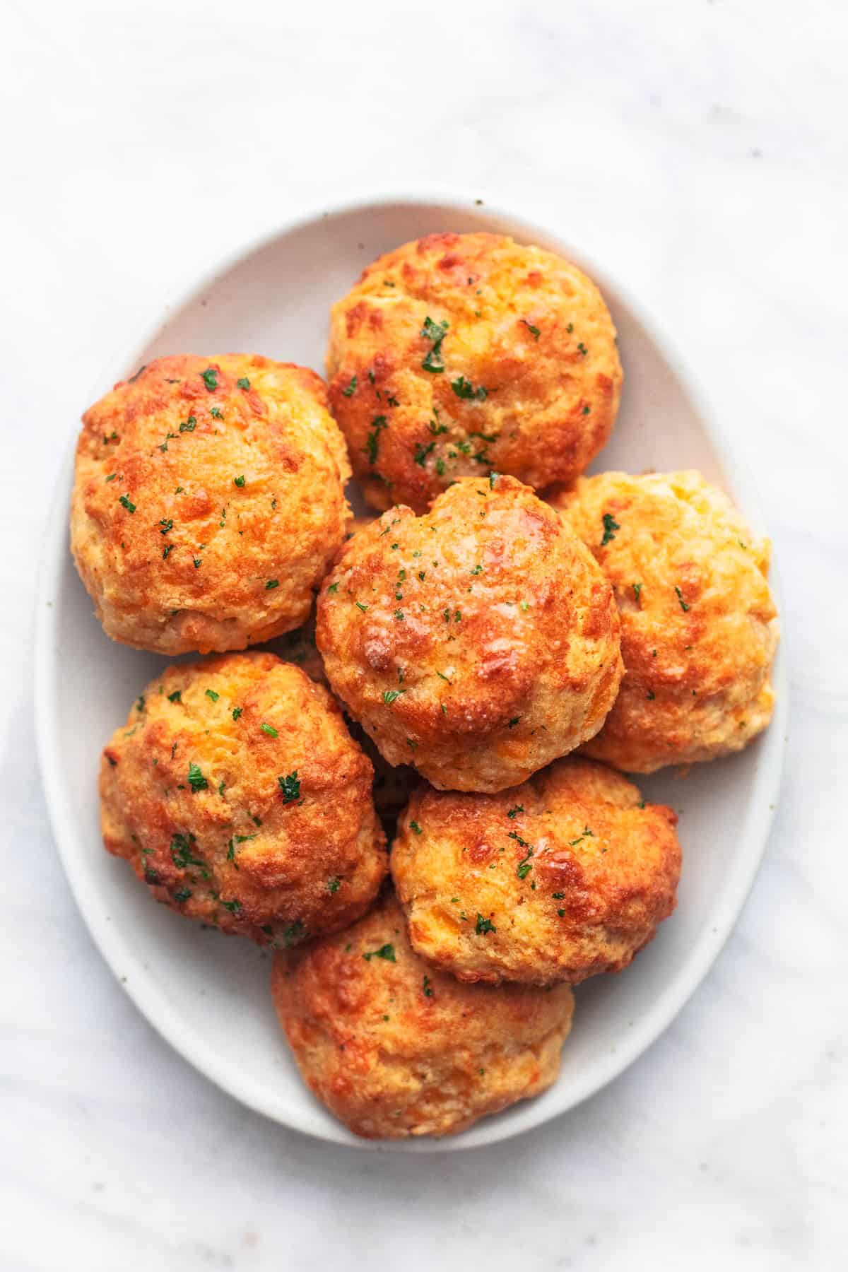 up close red lobster cheddar bay biscuits on a white plate on marble background